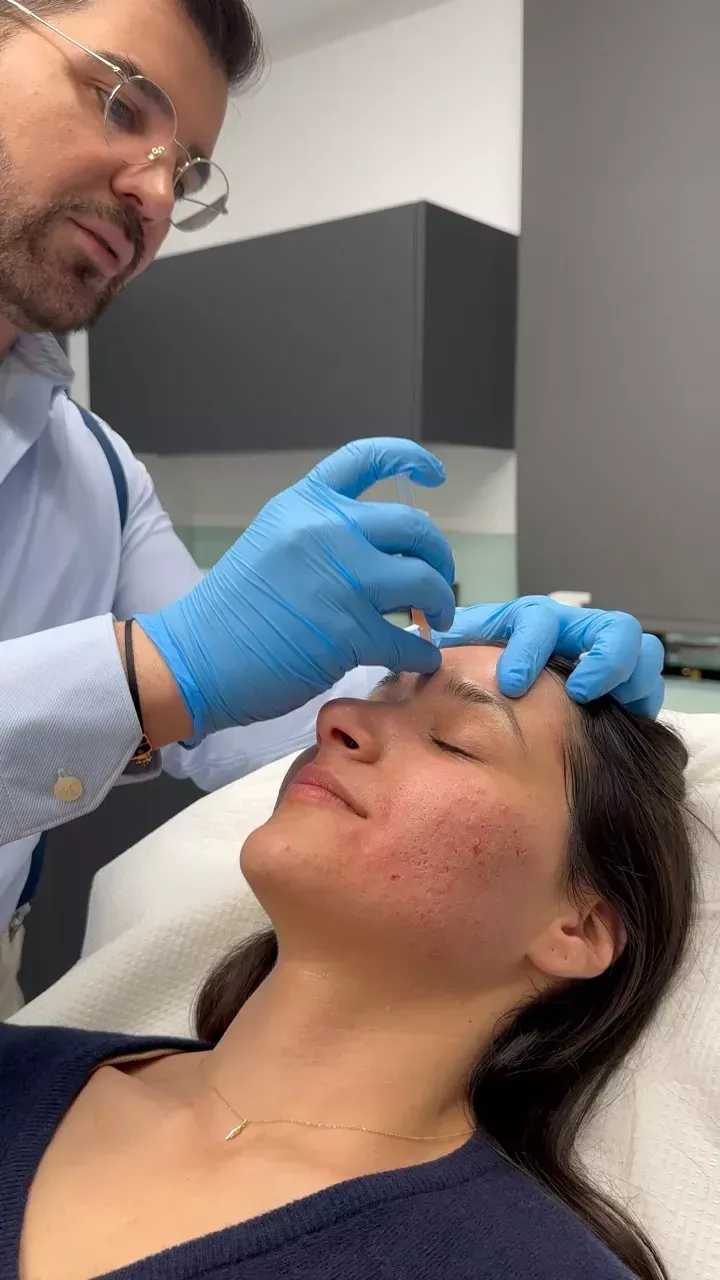 A dermatologist injects PRP into a patient for facial treatment.
