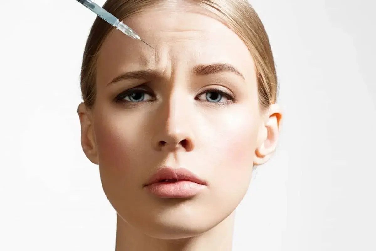 Γυναίκα κάνει Botox στο μέτωπο για ρυτίδες, με ένεση εντός του δέρματος.