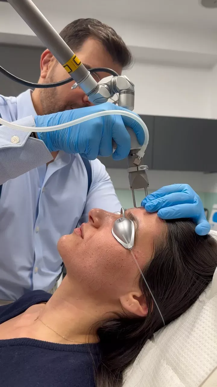 Woman receiving fractional laser treatment from a doctor. Pros and Cons of Fractional Laser: What You Need to Know.