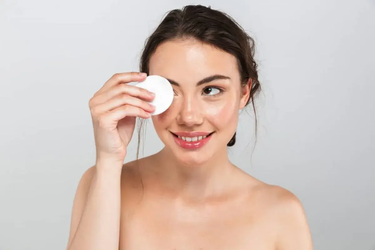 Facial Cleansing: Price, Benefits, Procedure: woman cleaning face with makeup remover pad